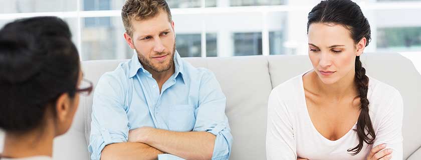 A married couple sitting slightly apart, the quiet distance of growing apart in a marriage